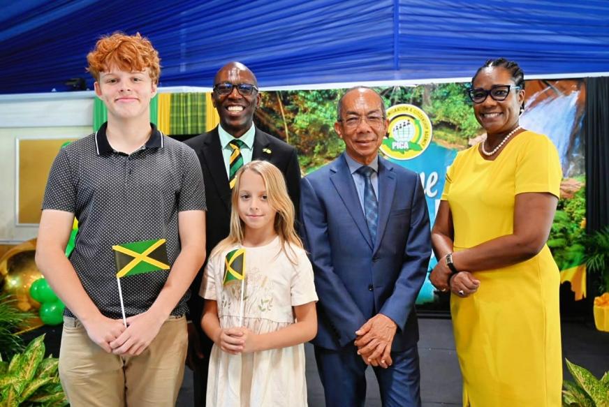 Deputy Prime Minister and Minister of National Security and Peace, the Hon. Dr. Horace Chang (2nd right), Permanent Secretary Ambassador Alison Stone Roofe (right) and PICA Chief Executive Officer Mr. Garth Williams (back, left) share a moment with two of Jamaica's newest citizens at the Citizenship Ceremony held at the Terra Nova Hotel in Kingston on Wednesday, July 22.