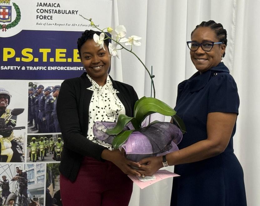 Permanent Secretary in the Ministry of National Security and Peace, Ambassador Alison Stone Roofe (right), accepts a token presented to her by Constable Chantel Fox of the Public Safety and Traffic Enforcement Branch (PSTEB), for her contribution to the success of PSTEB Women’s Conference 2026, held at the Police Officers’ Club on Thursday, July 2, 2026.